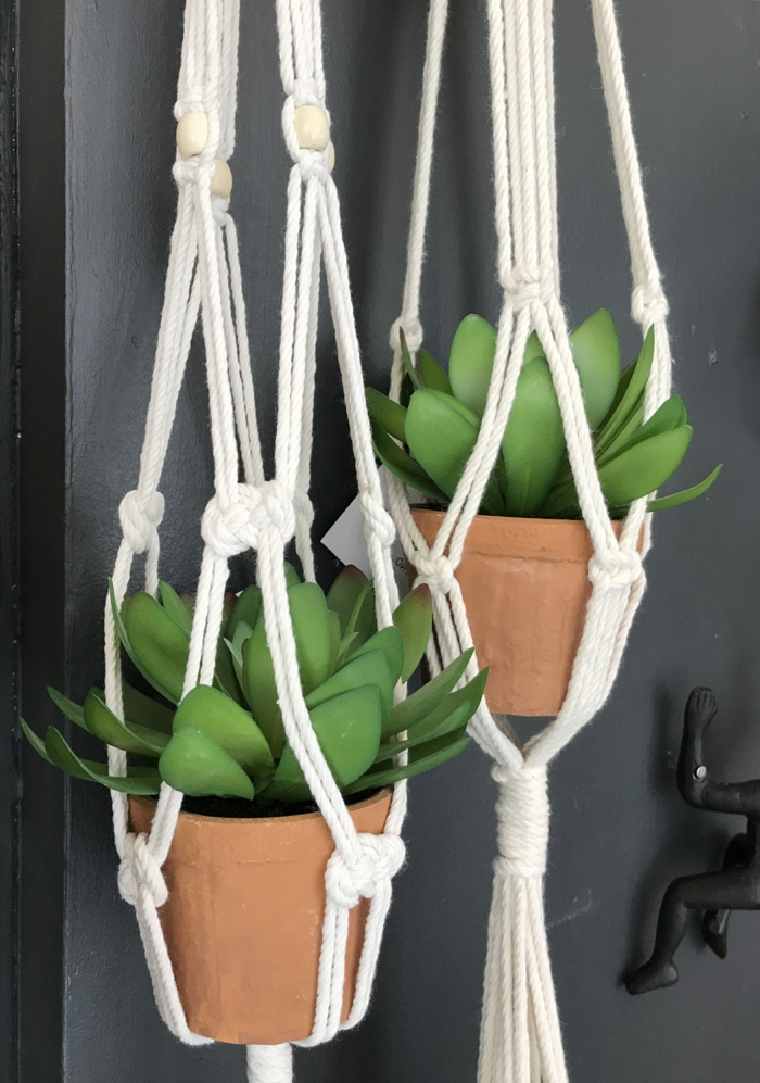 two ceramic plants hanging from the ceiling, black wall in the background, easy macrame plant hanger