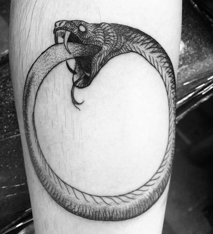 forearm tattoo, snake eating itself meaning, black and white photo