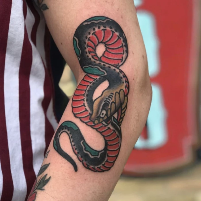snake eating itself tattoo, red black and green colors, side of the arm tattoo