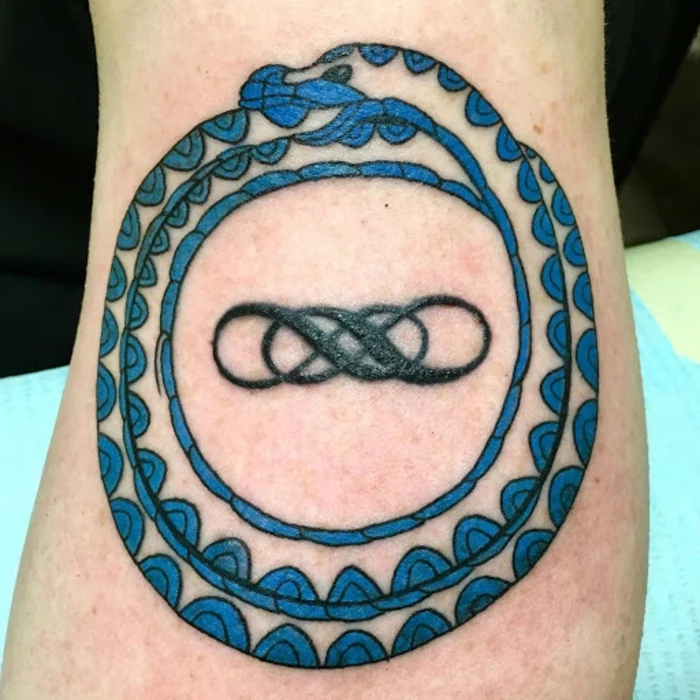 blue snake wrapped twice around two intertwining infinity symbols, snake eating itself tattoo, back of leg tattoo