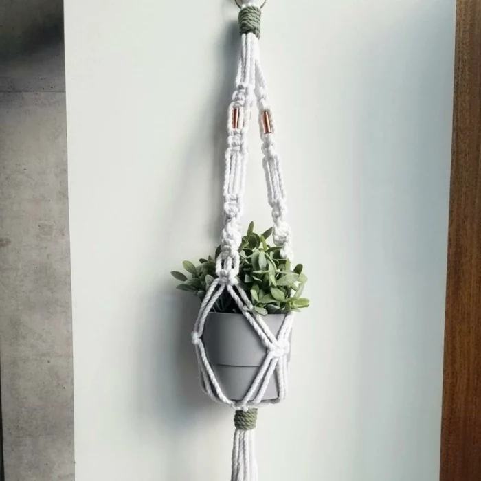 grey ceramic pot with plant inside, hanging on white wall, easy macrame plant hanger