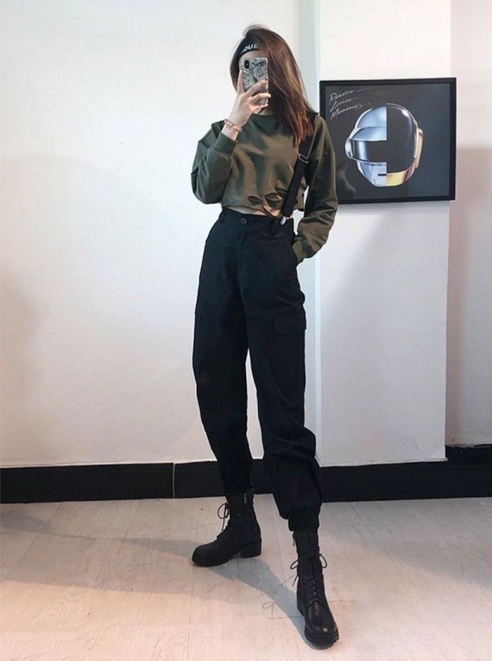 brunette girl wearing olive green crop top, black trousers with black suspenders, cute winter outfits for school, black leather boots