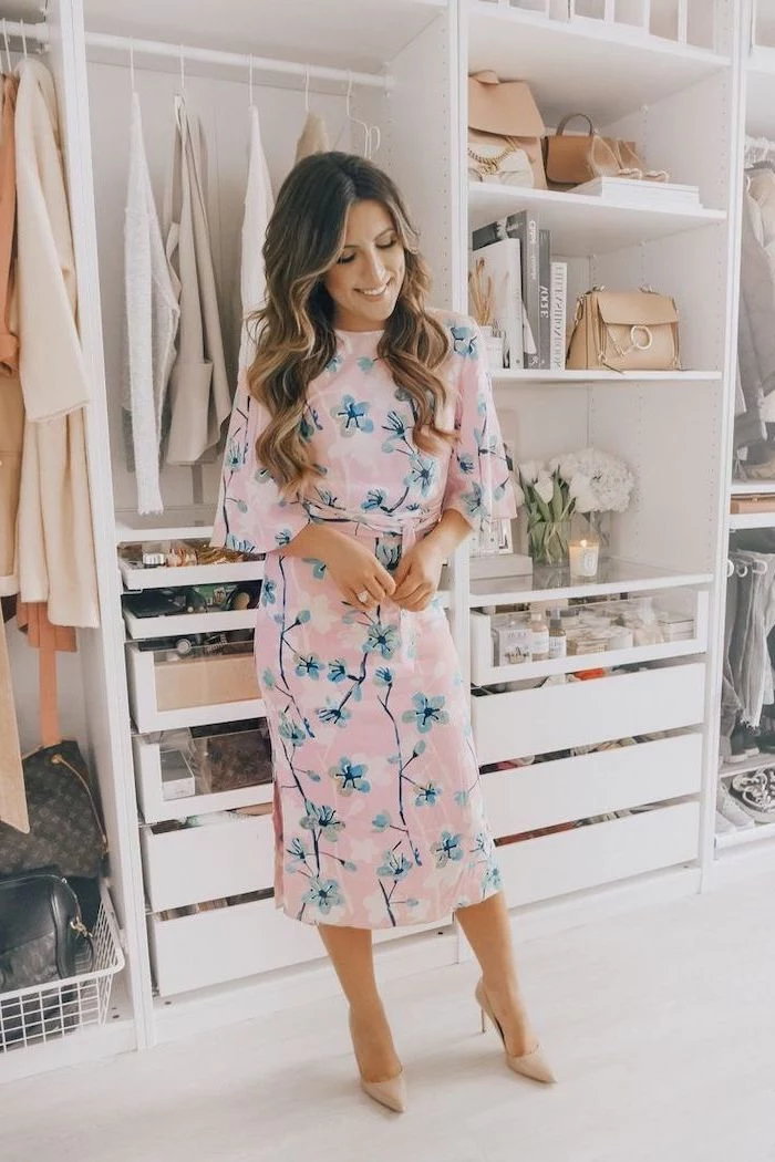 woman standing in a large closet, cute spring dresses, wearing a pink dress with floral print, nude heels