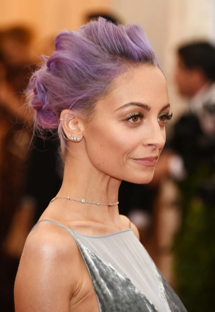 nicole richie, purple hair in a low updo, wearing silver velvet dress, stud cartilage piercing, multiple earrings