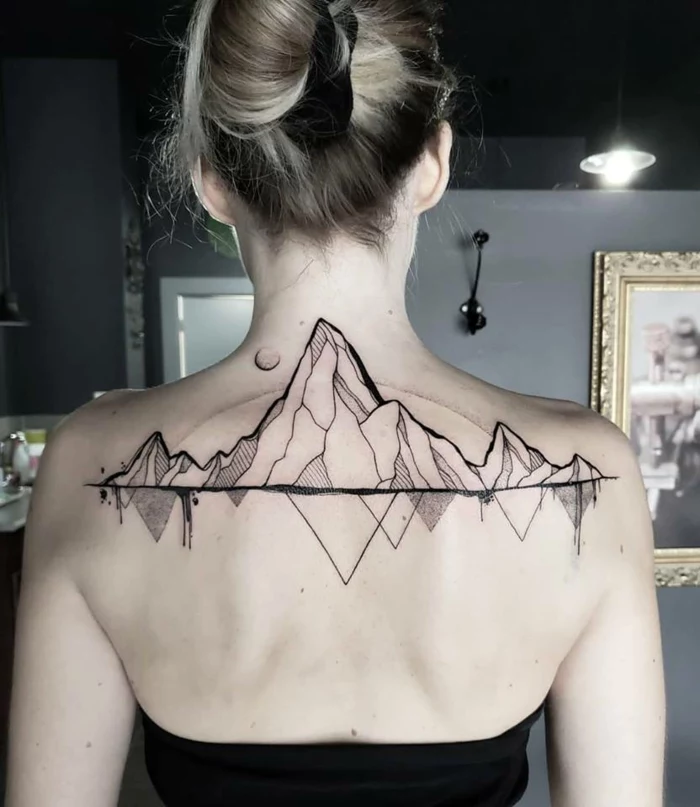 back tattoo, geometrical design, mountain range tattoo, woman with blonde hair in a bun