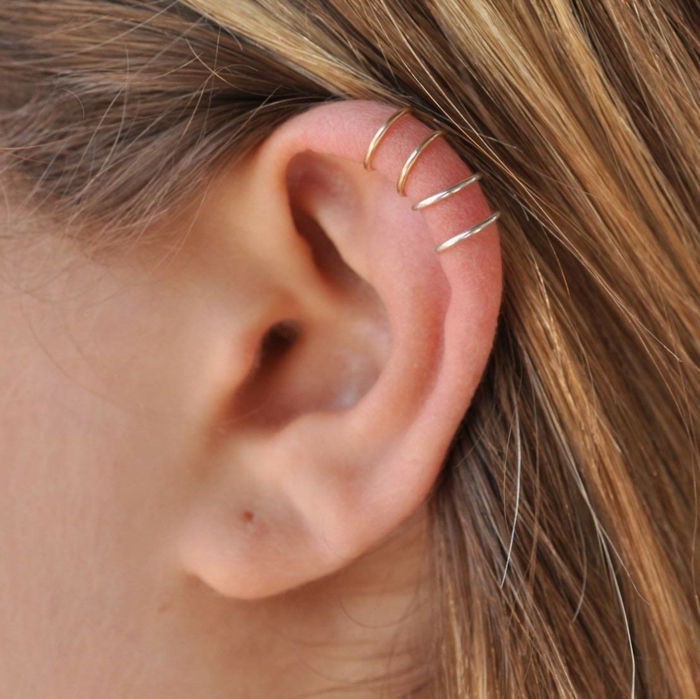 blonde woman, close up photo of her ear, double cartilage piercing, four golden ring earrings