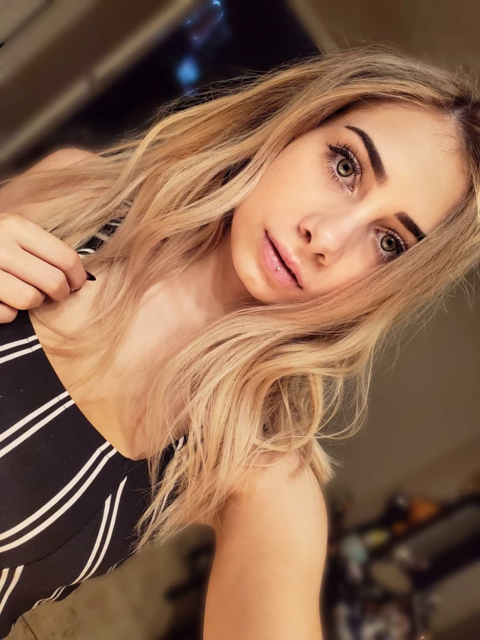 ashley piercing, girl with blonde wavy hair and green eyes, wearing black and white striped top