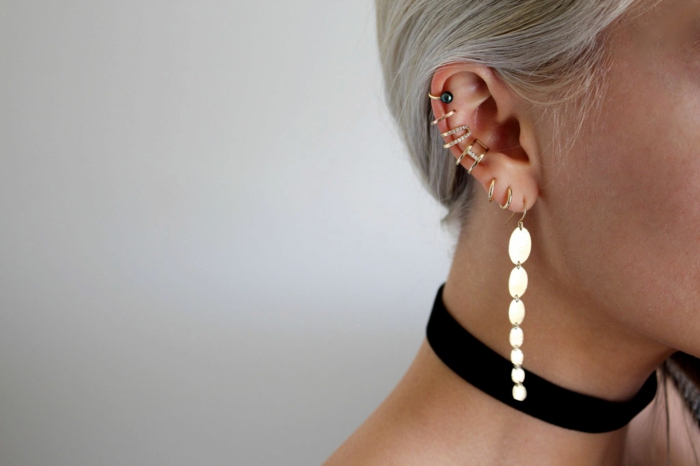 blonde woman, wearing black velvet choker, multiple earrings on her ear, double cartilage piercing