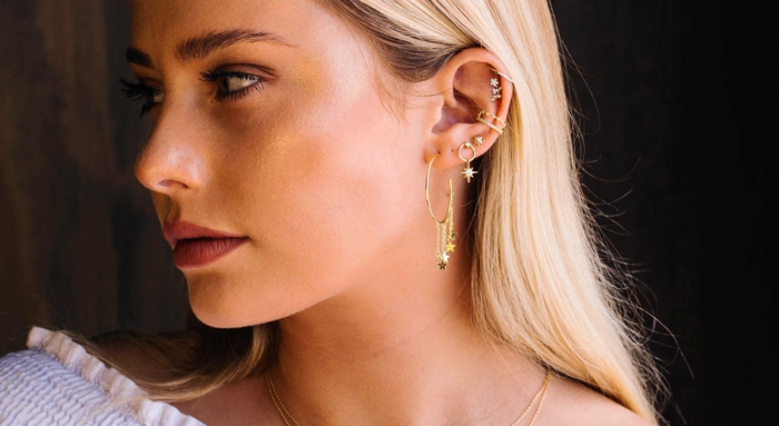 woman with blonde hair, wearing multiple different earrings, double helix piercing