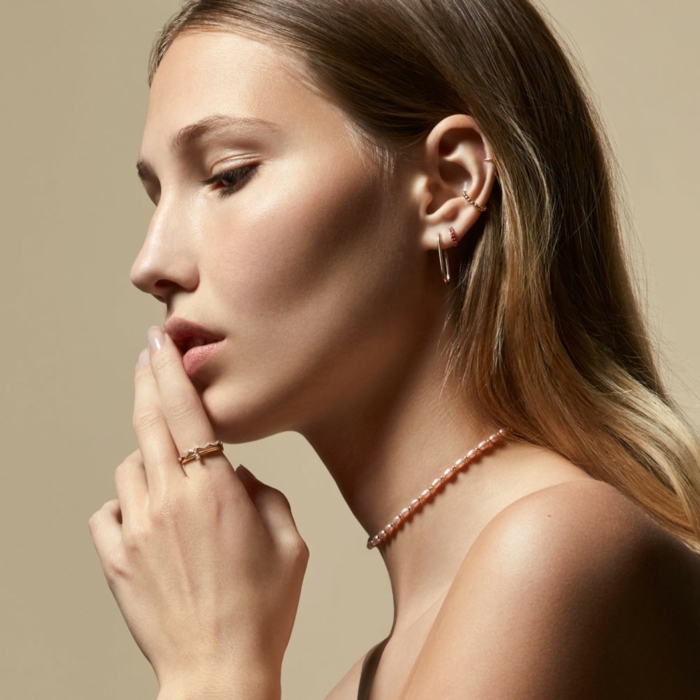 woman with blonde hair, wearing necklace choker and rings, double helix piercing, multiple earrings