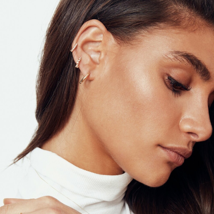 three ring earrings with rhinestones, double cartilage piercing, brunette woman, wearing white blouse