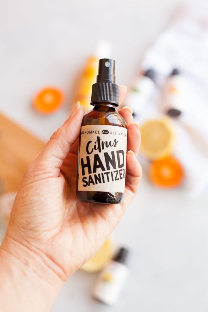 citrus hand sanitizer, brown spray bottle, held by female hand, hand sanitizer ingredients