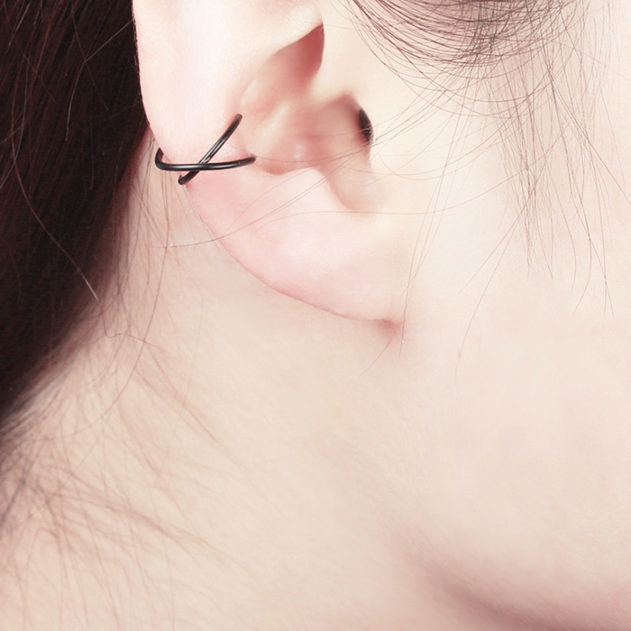 close up photo of an ear, woman with brown hair, forward helix piercing, two intertwining black ring earrings