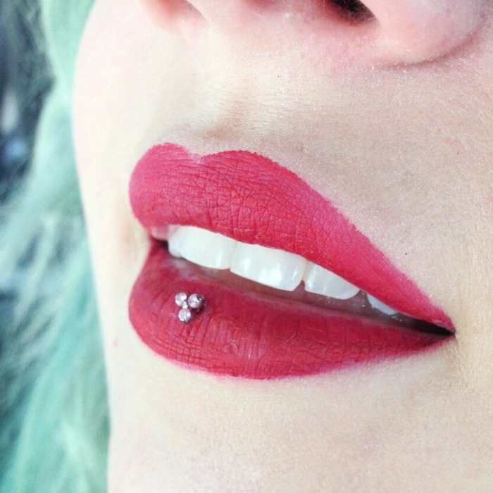 close up photo, lips with matte red lip gloss, labret piercing