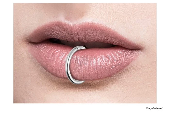 silver ring piercing, lip piercing names, close up photo, lips with pink matte lip gloss