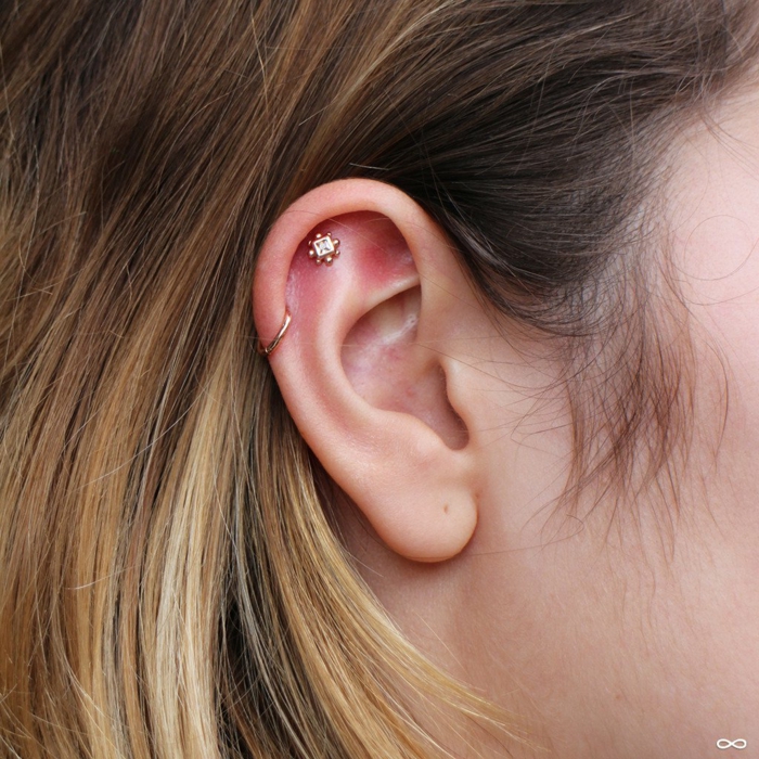 woman with blonde hair, close up photo, triple helix piercing, two golden earrings