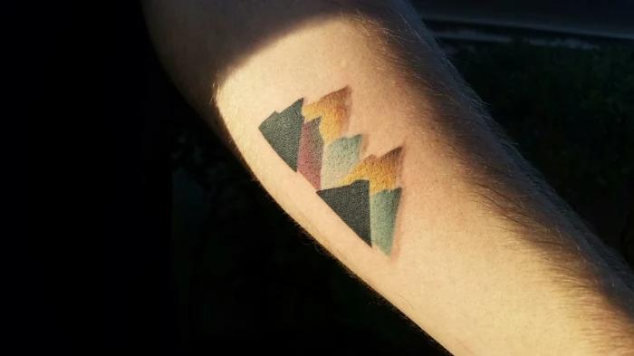 minimalist tattoo, forearm tattoo, colored mountain range, mountain tattoo, orange blue black and red colors
