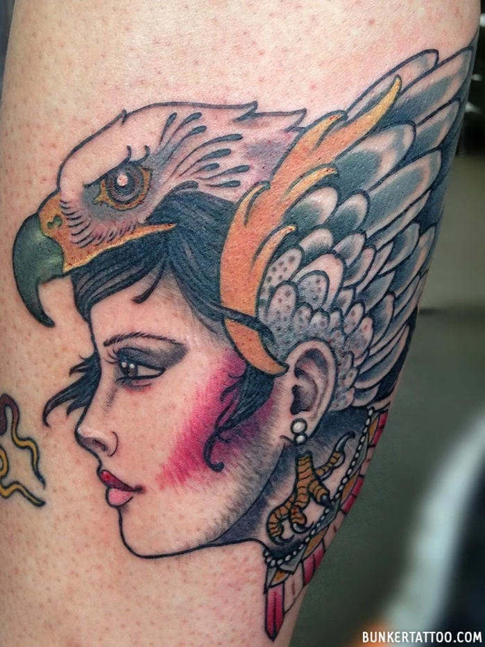 woman with black hair, falcon on her head, traditional tattoo designs, leg tattoo