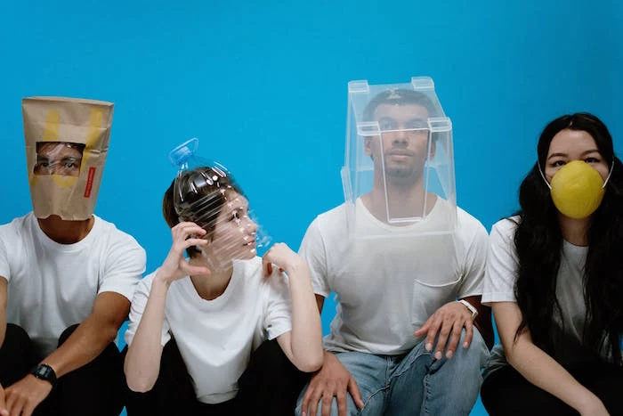 four people with different things placed on their heads, diy face mask for breathing, blue background