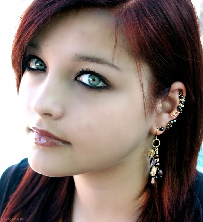 woman with red hair and green eyes, hoop cartilage piercing, wearing multiple earrings with black rhinestones