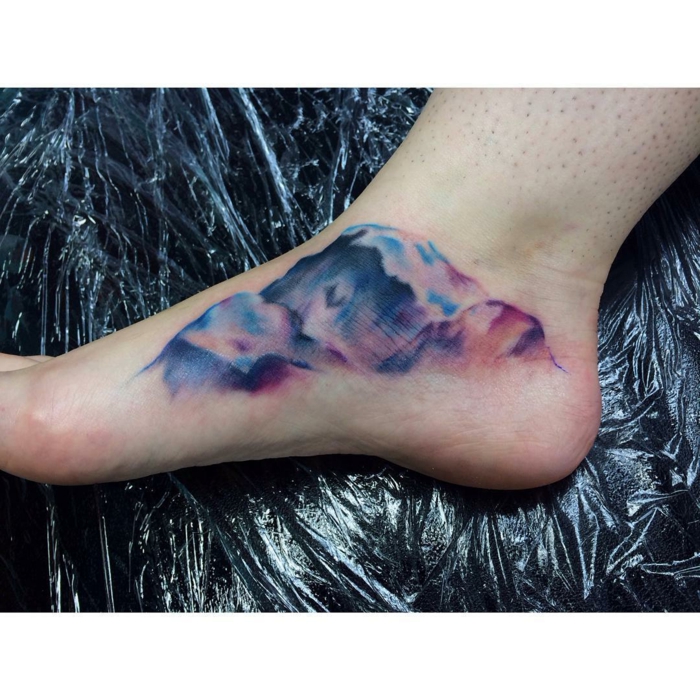 watercolor tattoo on the inside of the foot, mountain tattoo, mountain range in different colors