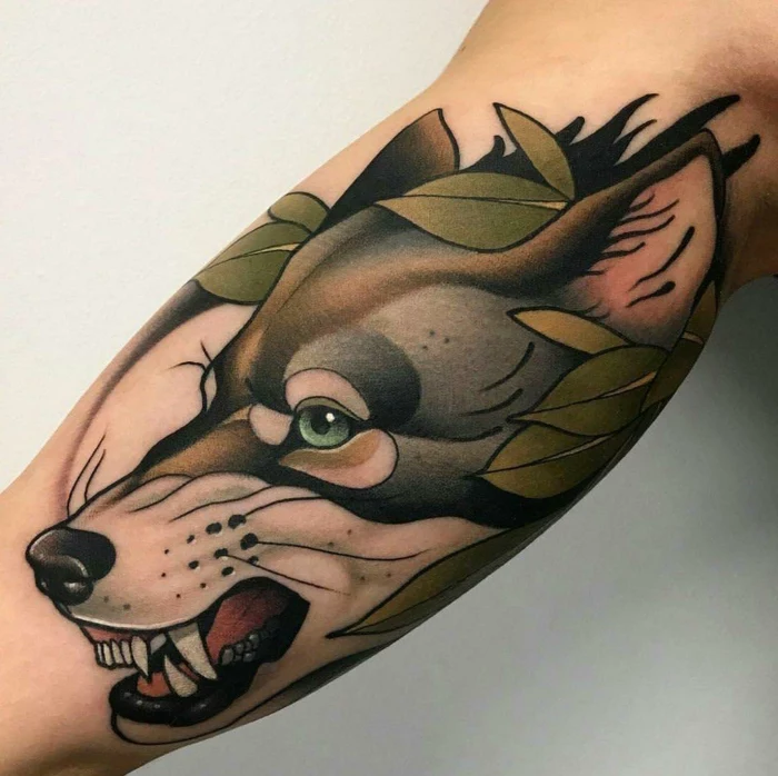 growling wolf head, surrounded by green leaves, what is a neo traditional tattoo, inside arm tattoo