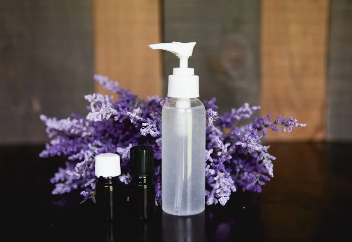 bouquet of lavender, two small bottle of essential oil, hand sanitizer, large plastic spray bottle