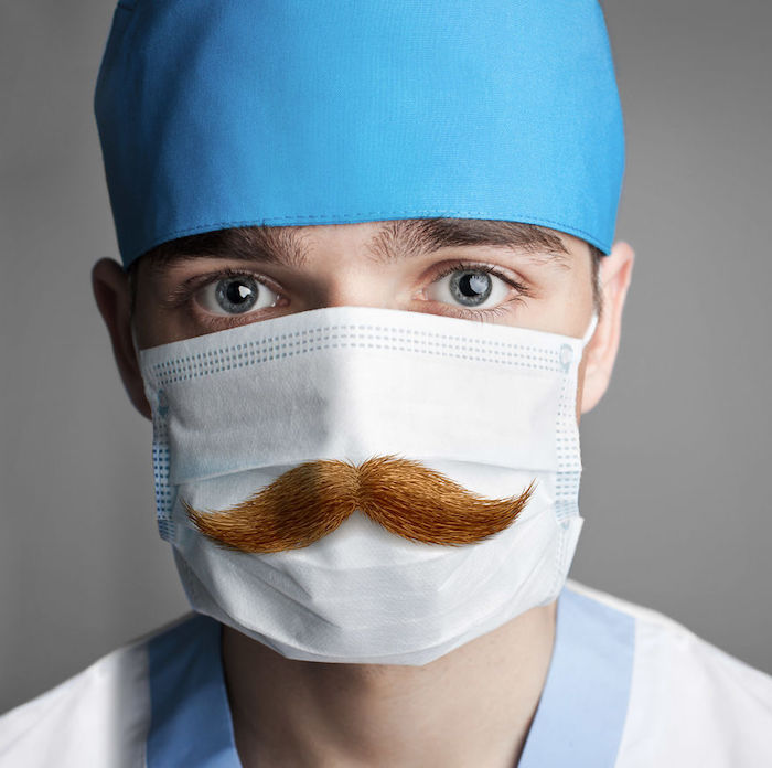 how to make a breathing mask, man with blue eyes, wearing a mask with moustache printed on it, surgical mask