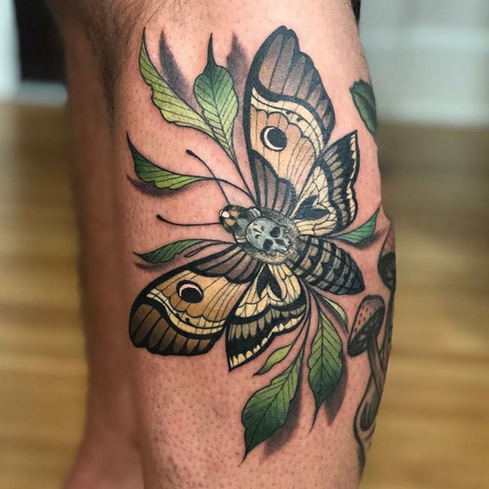 side of leg tattoo, large moth, surrounded by green leaves, neo traditional sleeve