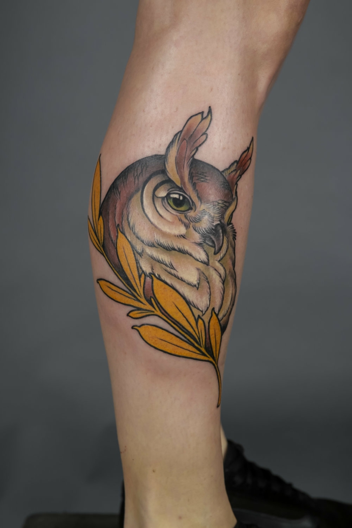 owl head, surrounded by golden leaves, side of the leg tattoo, what is a neo traditional tattoo