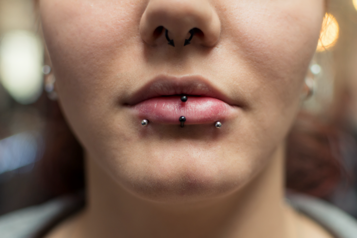 close up photo of woman's lips, types of lip piercings, septum piercing, lips with no lip gloss