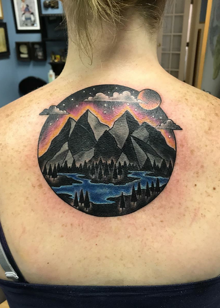 colored back tattoo, simple mountain tattoo, river flowing between trees, mountain range in the background