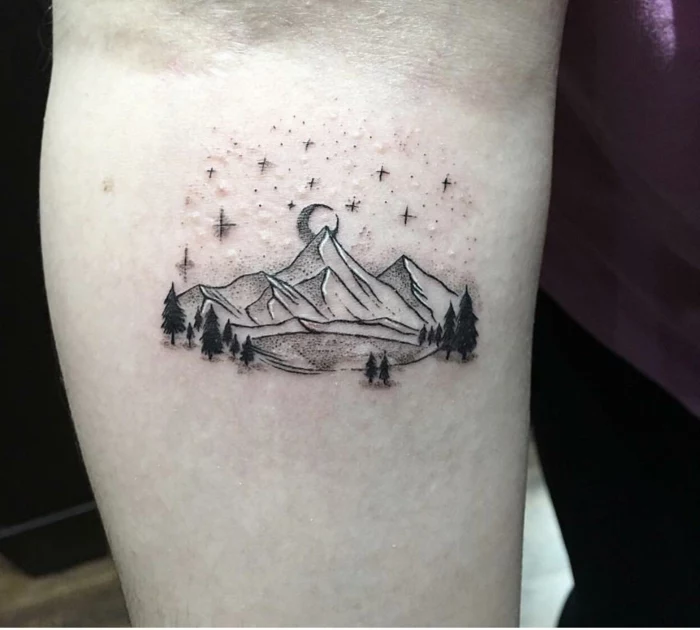 forearm tattoo, mountain scene tattoo, lake surrounded by trees and mountain, stars and moon in the sky
