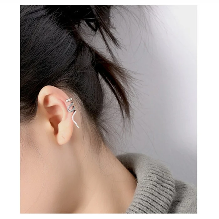 woman with black hair in a bun, wearing snake like silver earring with rhinestones, how long does a cartilage piercing take to heal