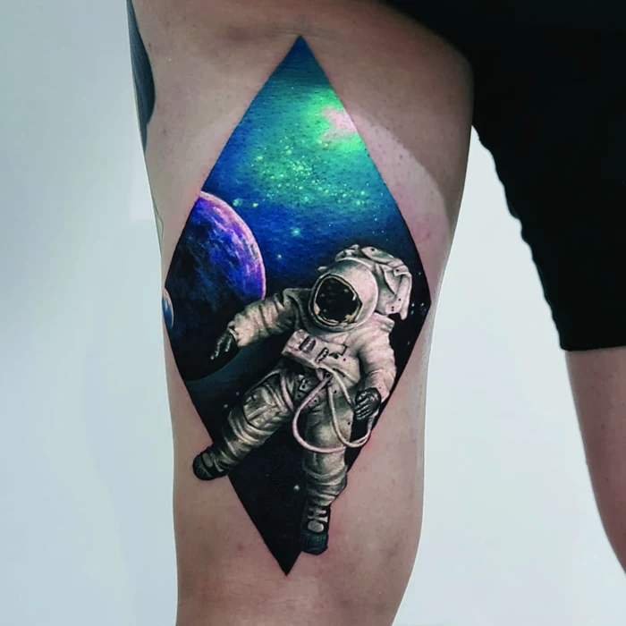 astronaut in space, traditional forearm tattoo, galaxy behind him, thigh tattoo
