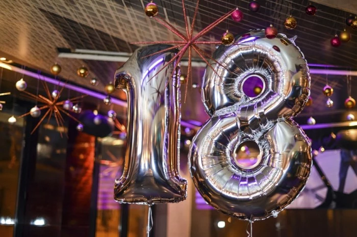 silver number 18 balloons, gifts for 18 year old boys, baubles hanging from the ceiling in purple and gold
