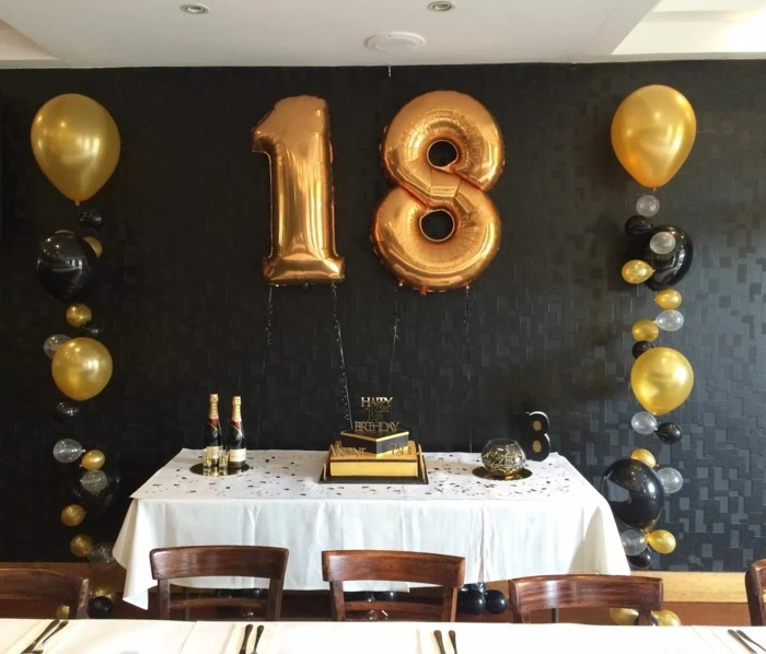 black and gold decor, large number 18 balloons, hanging on black wall, gifts for 18 year old boys, desserts table