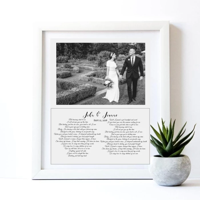 black and white photo of bride and groom, anniversary gifts by year, vows written underneath, inside a white wooden frame