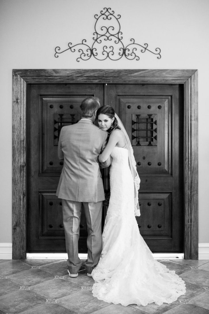 songs to walk down the aisle to, black and white photo, bride hugging her father, standing in front of a door