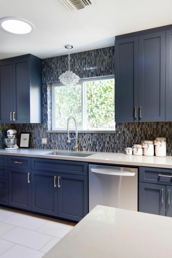 black cabinets with white countertop, modern kitchen cabinets, grey mosaic backsplash, white tiled floor