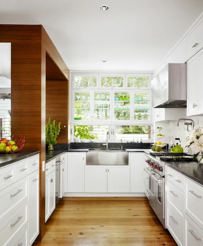 white cabinets with black granite countertops, laminated flooring, mid century modern kitchen