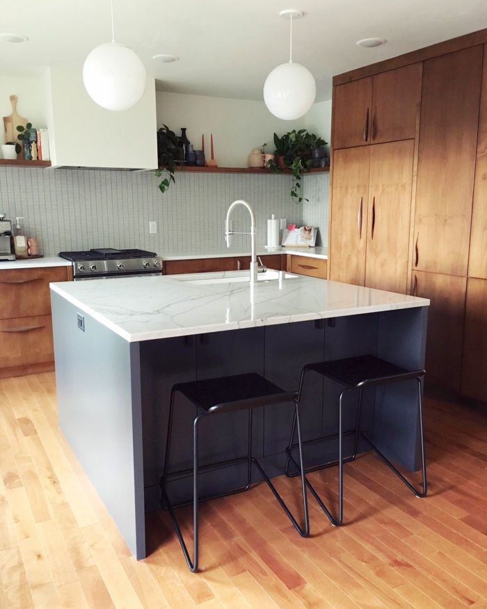 marble countertops, mid century kitchen, small kitchen island, black bar stools, wooden kitchen cabinets, open shelving