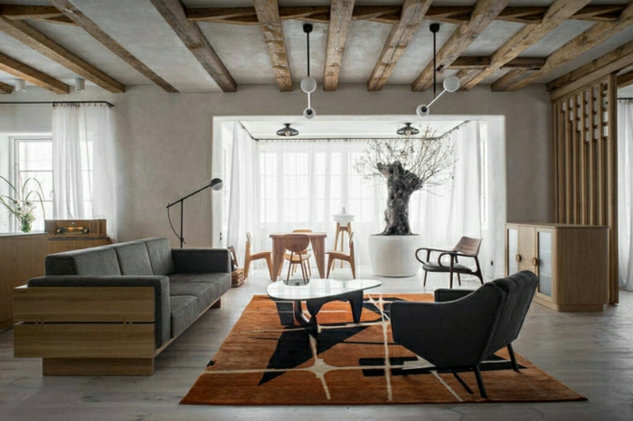 black sofa, wooden floor with orange carpet, how to decorate a living room, open plan space with living room and kitchen