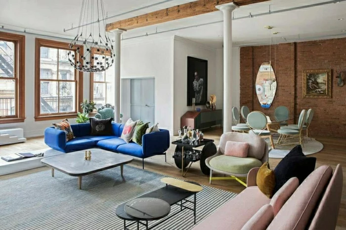 blue corner sofa with colorful throw pillows, modern living room, wooden floor and brick wall, wooden coffee table