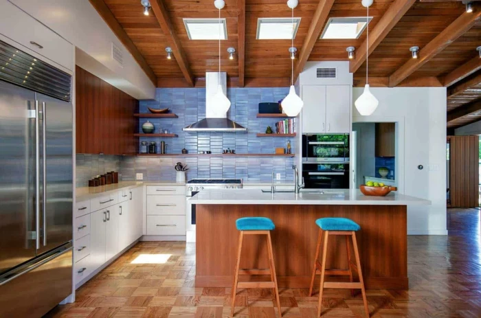 wooden kitchen island with white countertop, white cabinets, mid century modern cabinet, blue tiles backsplash