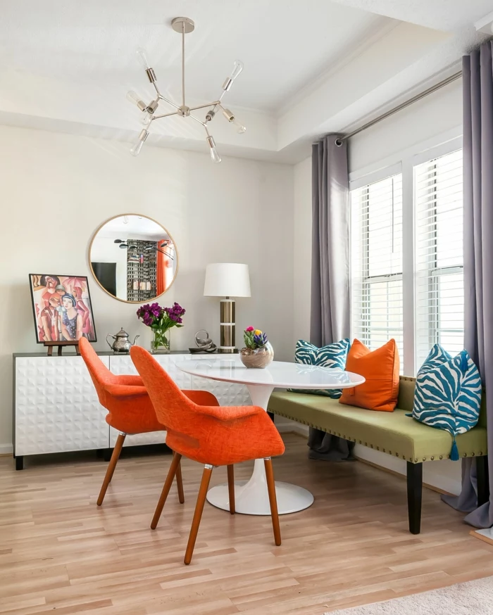 orange chairs, blue and orange throw pillows, modern kitchen cabinets, breakfast nook