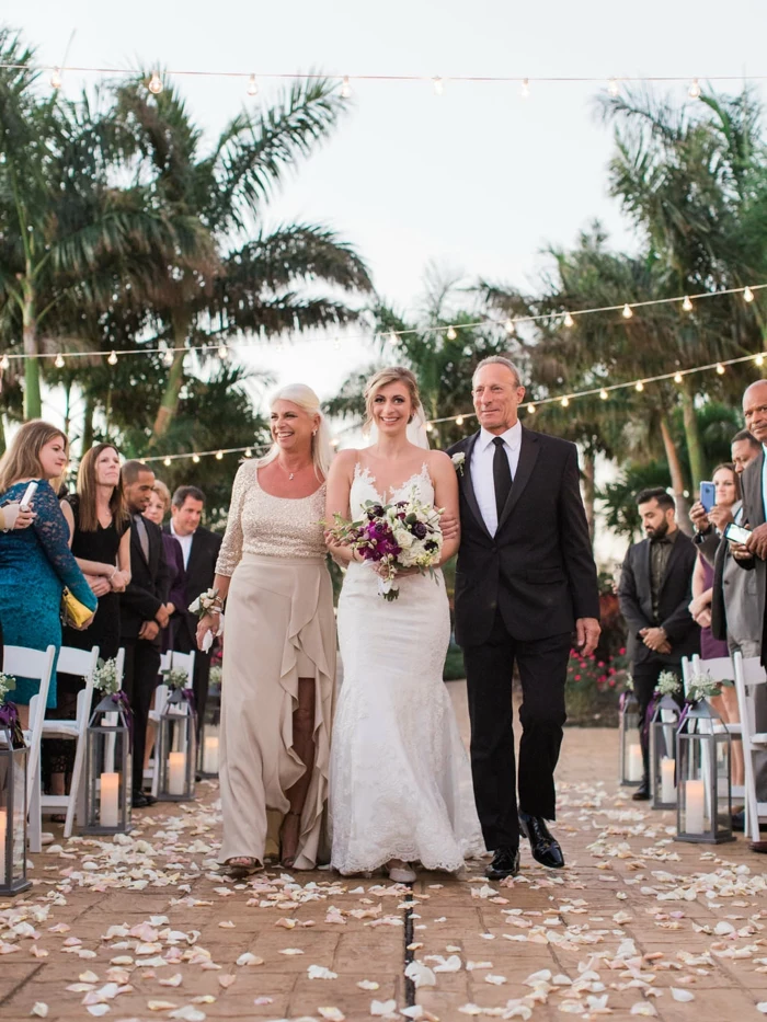 bride being walked down the aisle by her mother and father, palm trees in the background, songs to walk down the aisle to