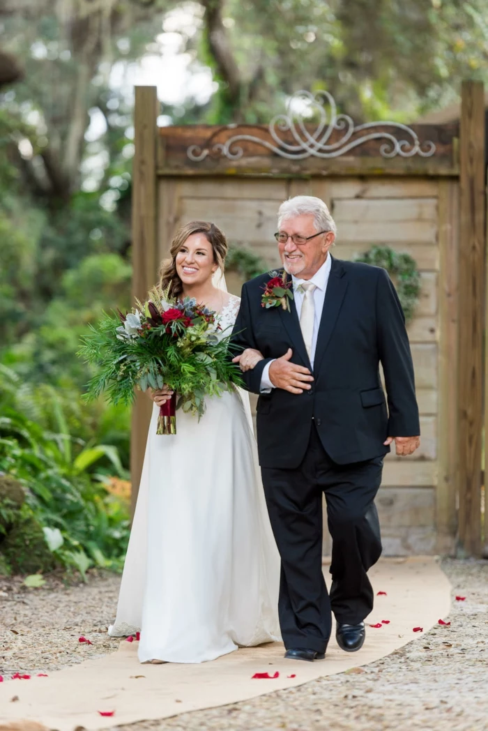 bride holding a large bouuet, being walked down the aisle by her father, wedding entrance songs, garden wedding