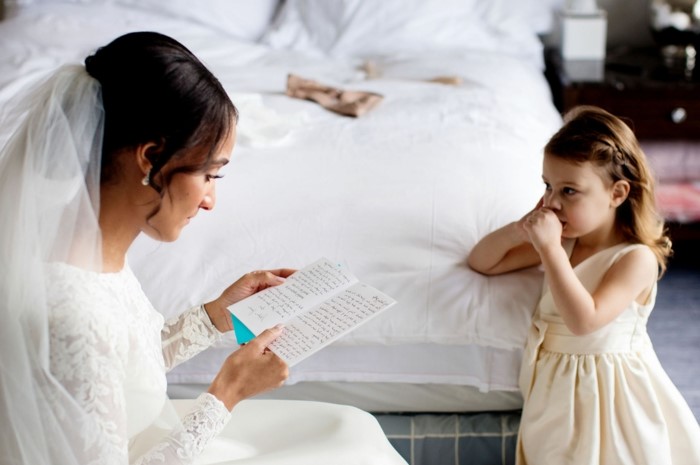 woman wearing wedding dress, rerading a card, what to say in a wedding card, little girl looking at her