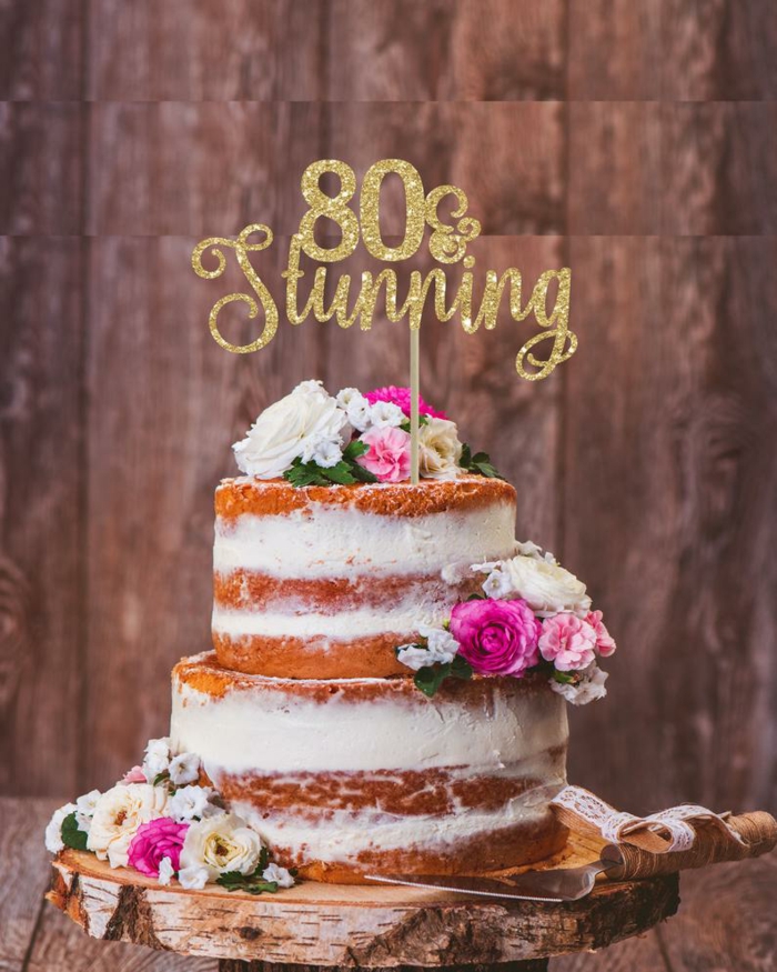 1001 80th Birthday Party Ideas To Get The Celebrations Started   Cake Placed On Wooden Cake Stand 80th Birthday Party Favors Decorated With Flowers 80 And Stunning Cake Topper 